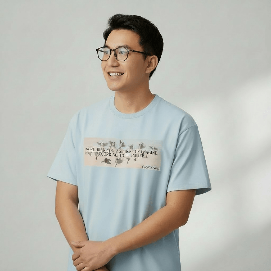 Person wearing a light blue t-shirt with text and graphics on a plain background