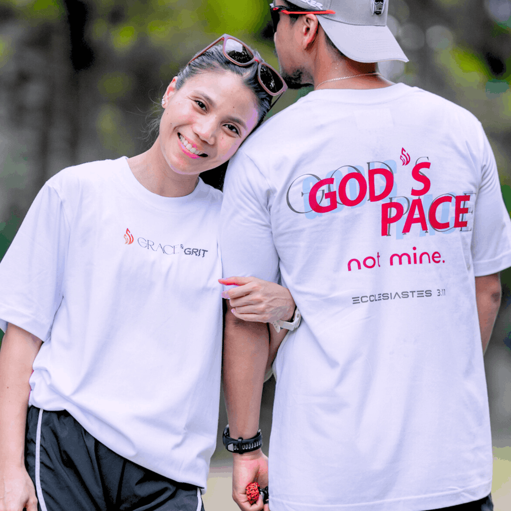 Two people wearing white t-shirt with text that says 'GOD'S PACE not mine.' and 'Ecclesiastes 3:11' below, standing close together outdoors