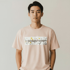 Person wearing a peach t-shirt with a graphic design on a plain background