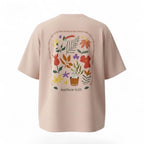 Peach t-shirt with floral design and 'Matthew 6:25' text on a white background