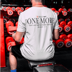 Person lifting weights with a motivationa whitel t-shirt in a gym setting