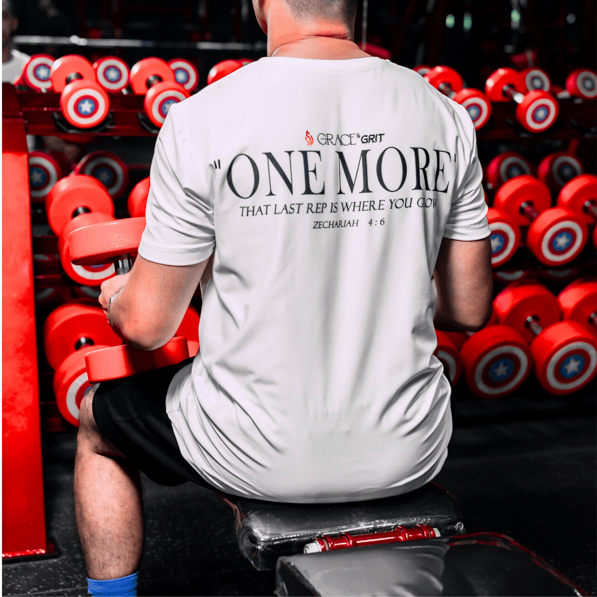 Person lifting weights with a motivationa whitel t-shirt in a gym setting