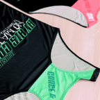 Two black running singlets with vibrant colored text and design (pink and black, mint and black) on a table