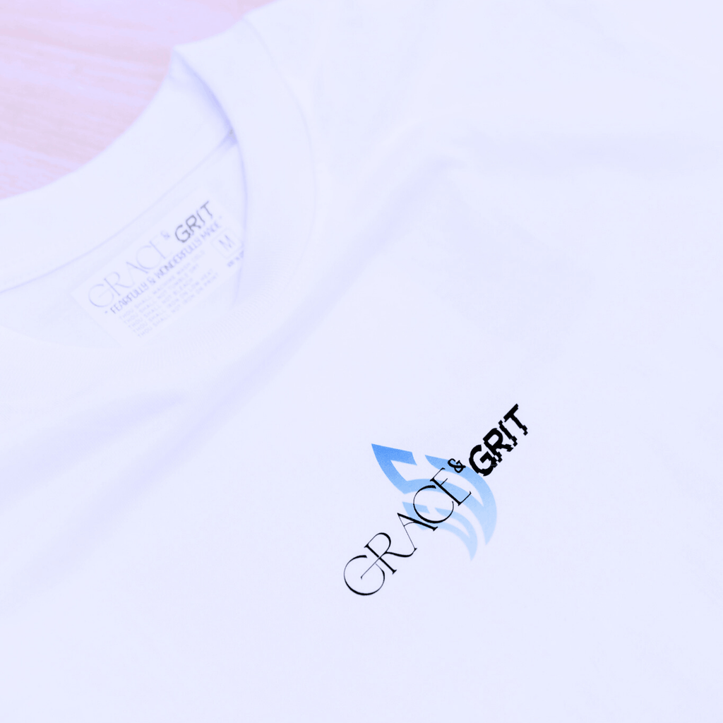 White t-shirt with a logo of Grace & Grit on a plain background