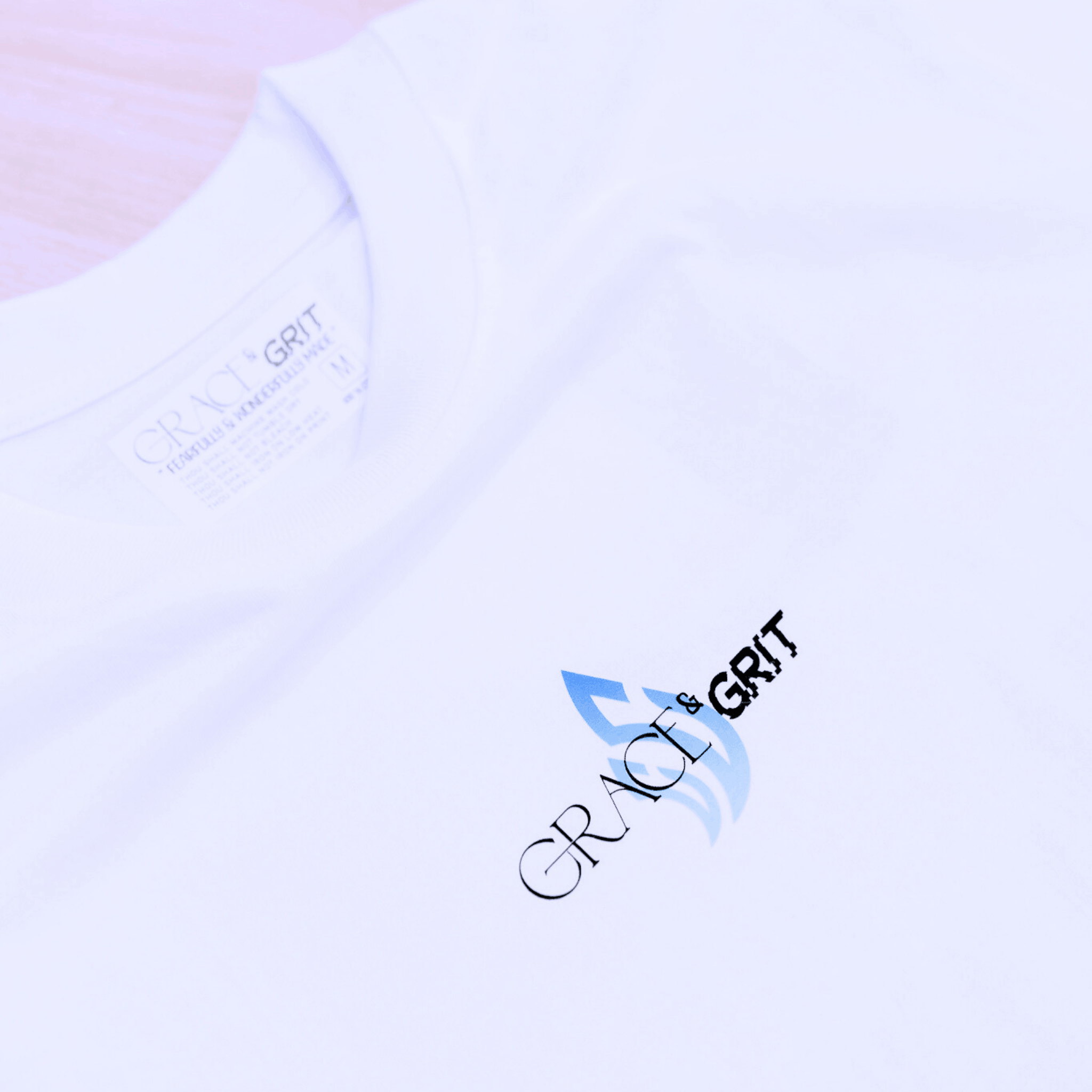 White t-shirt with a logo of Grace & Grit on a plain background