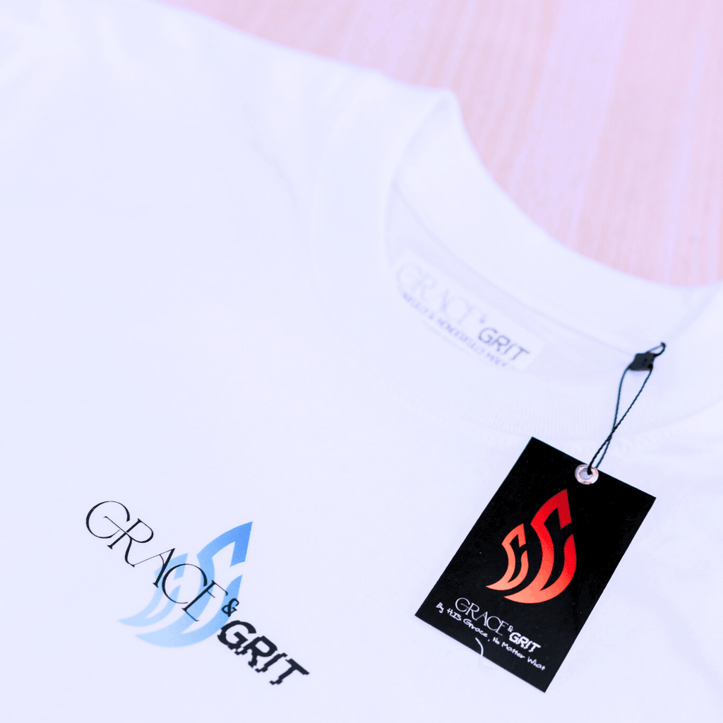 White t-shirt with a logo of Grace & Grit and tag on a plain background