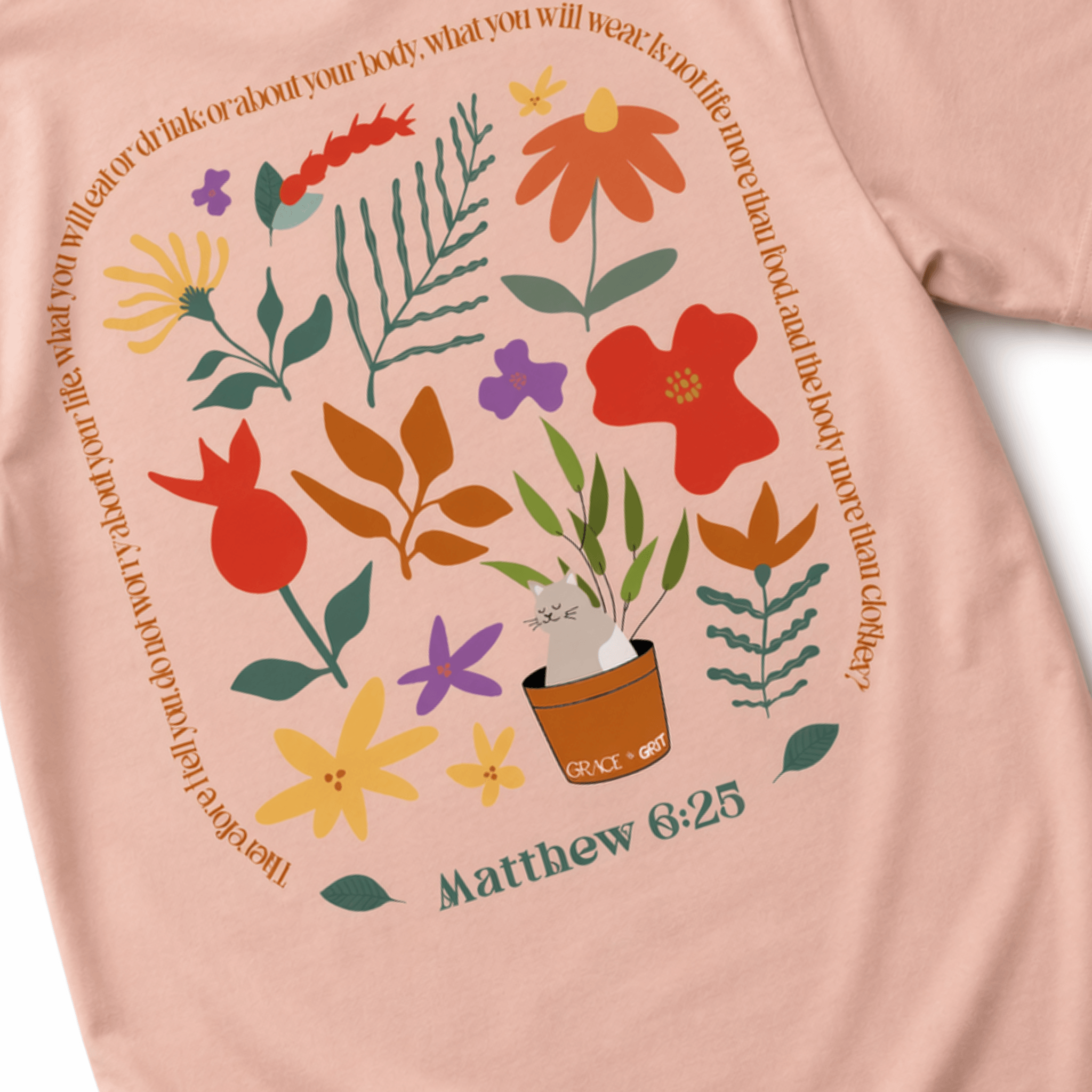 Peach t-shirt with floral design and 'Matthew 6:25' text on a white background